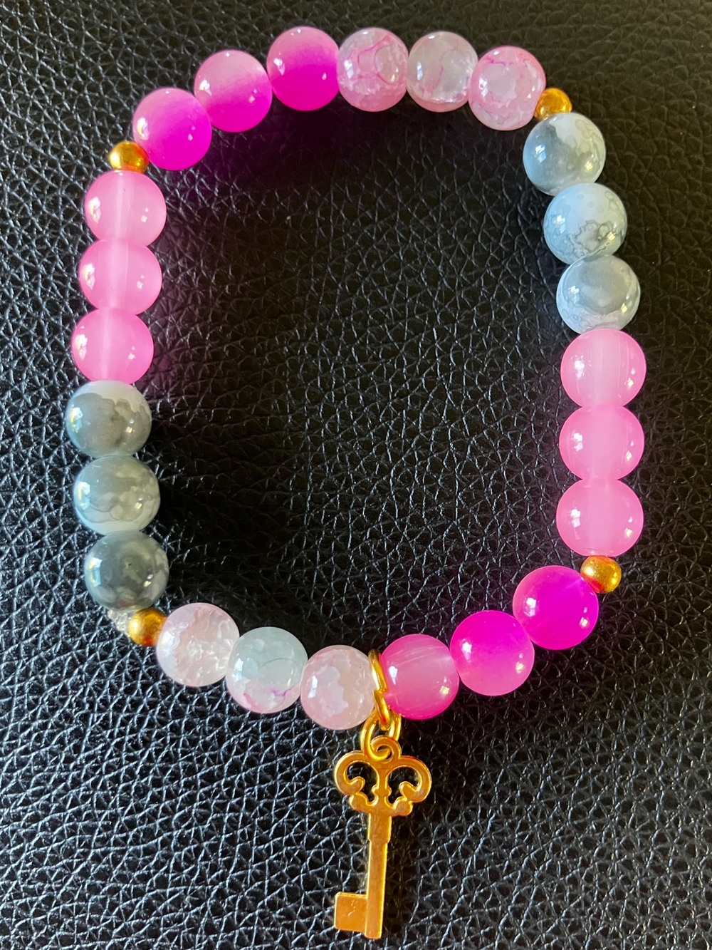 Pinks and grey glass beaded bracelet with heart key charm and gold accent